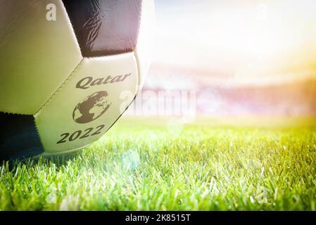 Dettaglio di una palla sull'erba di uno stadio di calcio che annuncia il torneo di Coppa del mondo in Qatar 2022. Foto Stock