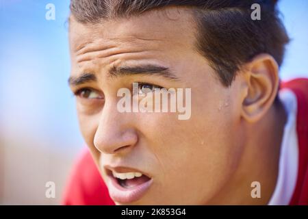 Giocatore di calcio, stanco e sudore sul viso dopo l'allenamento sportivo, gioco o partita sensazione di stanchezza e respirazione pesante all'aperto dopo l'allenamento. Calcio Foto Stock