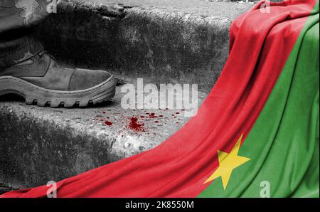 La gamba dei militari sta sul passo accanto alla bandiera del Burkina Faso, il concetto di conflitto militare Foto Stock