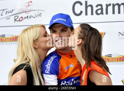 Tappa 3 del Tour di Romandy, Svizzera, Luis Leon Sanchez del team Rabobank festeggia come vince la scena e si alza sul podio per essere baciato da due ragazze podio Foto Stock