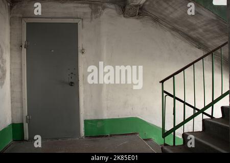 vecchio sporco ingresso sovietico in un edificio di appartamenti dopo un fuoco, un corridoio all'ingresso, una scala Foto Stock