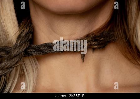 ragazza con una corda intorno al collo, traffico di esseri umani, schiavitù, potere sulle persone, una corda intorno al collo di una persona Foto Stock