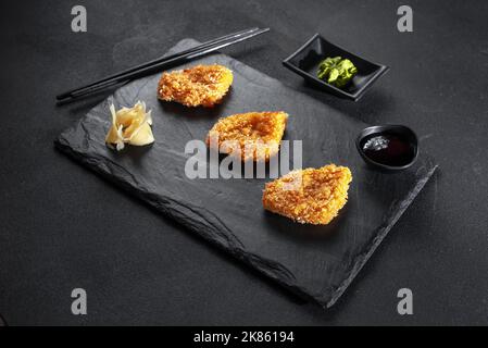 Pepite di pollo fritte cinesi in pastella su sfondo nero. Cucina asiatica. Foto Stock