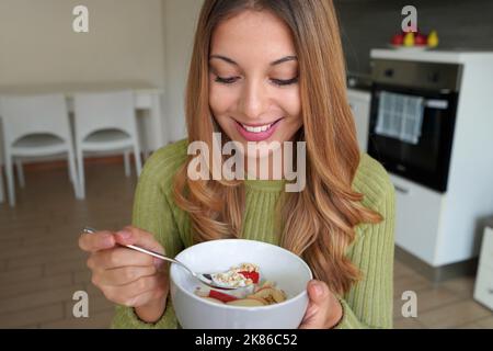 Ragazza adolescente che mangia muesli farina d'avena con frutta e yogurt Foto Stock