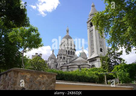 PARIGI, FRANCIA - 6 GIUGNO 2022: La Basilica del Sacro cuore di Montmartre (Sacro cuore di Montmartre) vista posteriore dal giardino Foto Stock