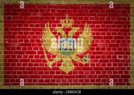 Un'immagine della bandiera del Montenegro dipinta su un muro di mattoni in una collocazione urbana Foto Stock