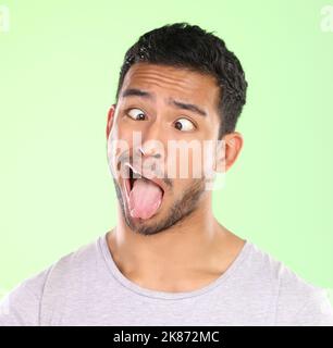 Mia mamma pensa im bello. Un bel giovane che fa un volto su uno sfondo verde in studio. Foto Stock