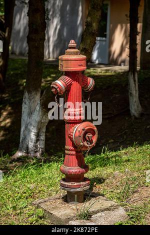 Idrante rustico di colore rosso nel campus studentesco di Petrosani Foto Stock