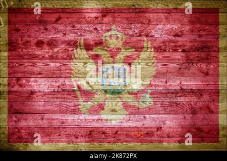Un vignettato immagine di sfondo di bandiera del Montenegro verniciato su assi di legno di una parete o di pavimento. Foto Stock