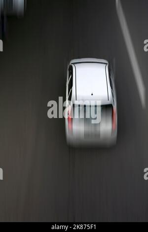 Traffico sulla strada. Auto bianca in movimento, movimento sfocato. Vista aerea Foto Stock