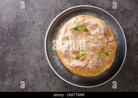 Grande torta Choux eclair con riempimento della crema primo piano in un piatto sul tavolo. Vista dall'alto orizzontale Foto Stock