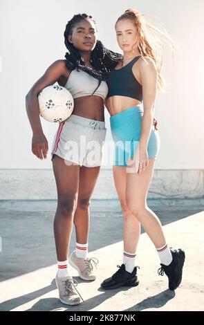 Fitness, calcio e ritratto di atlete in piedi con una palla in città per l'allenamento sportivo. Calcio, allenamento e sana ragazza interracial Foto Stock