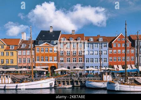 Copenaghen, Danimarca - Settembre 2022: Colorata architettura tradizionale casa e barche sul terrapieno del canale nel porto di Nyhavn Foto Stock