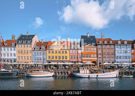 Copenaghen, Danimarca - Settembre 2022: Colorata architettura tradizionale casa e barche sul terrapieno del canale nel porto di Nyhavn Foto Stock