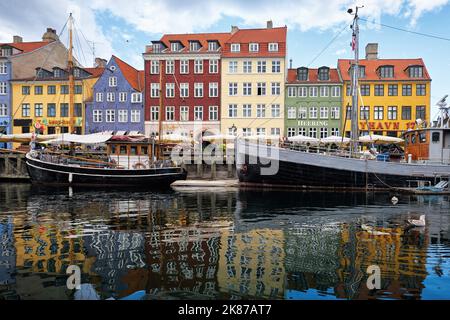 Copenaghen, Danimarca - Settembre 2022: Colorata architettura tradizionale casa e barche sul terrapieno del canale nel porto di Nyhavn Foto Stock