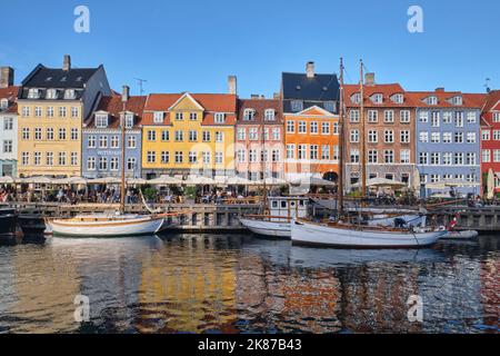 Copenaghen, Danimarca - Settembre 2022: Colorata architettura tradizionale casa e barche sul terrapieno del canale nel porto di Nyhavn Foto Stock