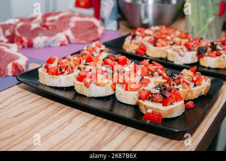 sandwich di pesce e pomodoro su un piatto nero Foto Stock