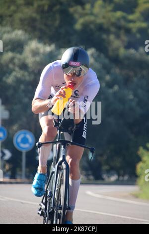 triatleta in bicicletta bevendo da una bottiglia d'acqua Foto Stock