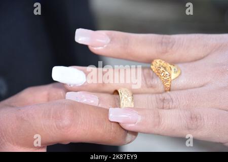 le mani degli sposi novelli al matrimonio, lo sposo mette l'anello d'oro del matrimonio sul dito della sposa Foto Stock