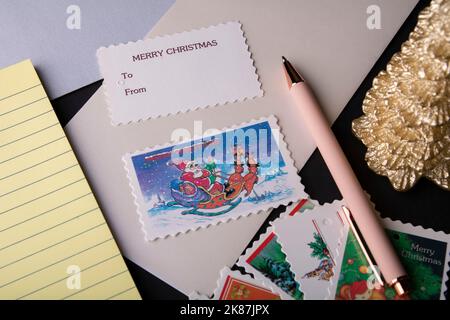 busta sul tavolo con una cartolina e timbri Foto Stock