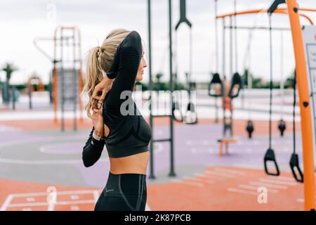 Forte atletica donna allunga i suoi muscoli dopo l'allenamento di forza. Foto Stock