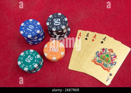 Quattro assi vicino pile di fiches su un tavolo di feltro rosso. Il gioco del poker è uno dei giochi di carte più popolari al mondo e ha giocato molto nei casinò. Scheda Foto Stock