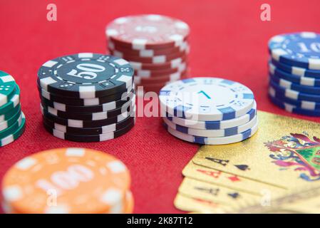 Quattro assi vicino pile di fiches su un tavolo di feltro rosso. Il gioco del poker è uno dei giochi di carte più popolari al mondo e ha giocato molto nei casinò. Scheda Foto Stock