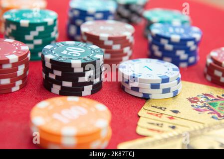 Quattro assi vicino pile di fiches su un tavolo di feltro rosso. Il gioco del poker è uno dei giochi di carte più popolari al mondo e ha giocato molto nei casinò. Scheda Foto Stock