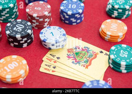 Quattro assi vicino pile di fiches su un tavolo di feltro rosso. Il gioco del poker è uno dei giochi di carte più popolari al mondo e ha giocato molto nei casinò. Scheda Foto Stock