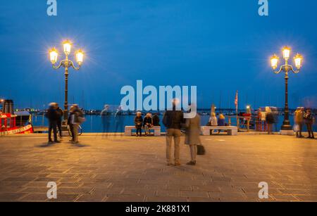 Turisti e gente del posto che si rilassano e lavorano sul lungomare del Porto - Chioggia Laguna di Venezia, Veneto regione, Italia, fotografia notturna - lunga esposizione Foto Stock