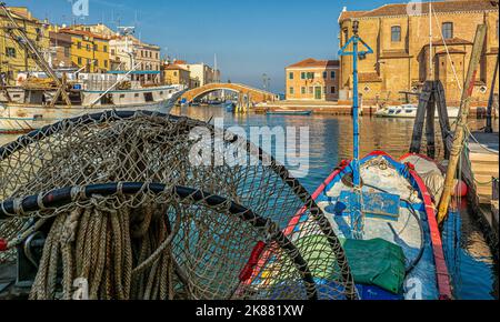 Paesaggio urbano della città di Chioggia con stretto canale d'acqua con barche ormeggiate, edifici - laguna veneta, provincia di Venezia, Italia settentrionale Foto Stock