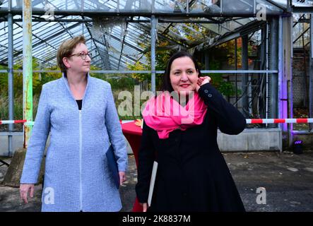 21 ottobre 2022, Brandeburgo, Cottbus/OT Branitz: Klara Geywitz (l, SPD), Ministro federale dell'edilizia e dell'edilizia, e Manja Schüle (r, SPD), Ministro della scienza, della ricerca e della cultura del Brandeburgo, si trovano di fronte a una ex serra nel Parco all'aperto di Branitz, sulla base della futura "Università del nuovo edificio". È stato presentato il progetto modello del governo federale "New Tree University Branitz" per la conservazione dei giardini storici nel cambiamento climatico. Una nuova era della Branitz Tree University, di 176 anni, verrà fondata sul terreno di un antico giardino di mercato. Il parco all'aperto w Foto Stock