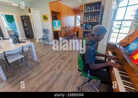 Highland Park, Michigan - Musanna Ali, 17, suona il pianoforte presso la casa di lavoro. Il no profit aiuta gli studenti in questa comunità a basso reddito con tutor Foto Stock