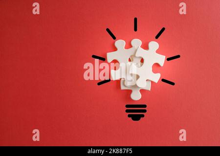 Lampadina da puzzle su sfondo rosso con spazio di copia. Ispirazione, concetto di idea creativa. Foto Stock