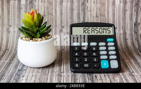 Calcolatrice con motivi testuali su sfondo in legno con fiore di cactus Foto Stock