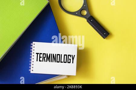 Blocco note con terminologia di testo su sfondo giallo con cartelle blu Foto Stock