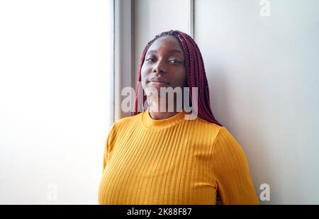 Ritratto di donna afroamericana con capelli rossi intrecciati Foto Stock