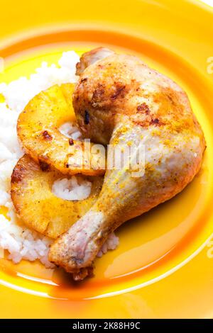 coscia di pollo alla griglia servita con fette di ananas fritte e riso Foto Stock