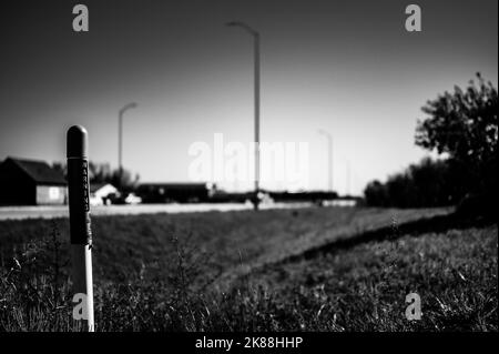 Posto marcatore per la linea ottica sotterranea di internet lungo un fosso stradale. Foto Stock