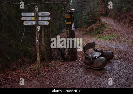 Hinterweidenthal, Germania - 1 gennaio 2021: Segni accanto ad una panca a forma di scarpe nella foresta di Palatinato della Germania vicino a Devil's Table su una w Foto Stock