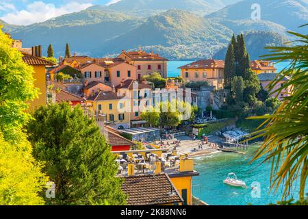 Vista ad alto angolo da una strada sopra il pittoresco villaggio di Varenna sul lago, con il colorato centro storico e la marina vista sul lago di Como. Foto Stock