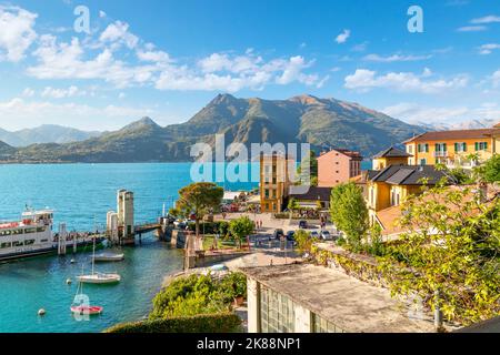 Vista ad alto angolo da una strada sopra il pittoresco villaggio di Varenna sul lago, con il colorato centro storico e la marina vista sul lago di Como. Foto Stock