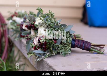 I mazzi dei fiori delle feste nuziali sono sdraiati per drenare l'acqua dalle rose prima della cerimonia. Foto Stock