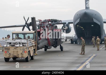 I soldati assegnati a Delta Company, 1-229 Battaglione di attacco, 16th Brigata di Aviazione di combattimento, rimorchiano un elicottero AH-64E Apache Attack al Gray Army Airfield, Washington il 20 ottobre 2022. I soldati si preparavano ad allenarsi con Airmen sulle procedure di carico e scarico dell'elicottero Apache AH-64E C-17. (STATI UNITI Foto dell'esercito di Capt. Kyle Abraham, 16th Brigata dell'aviazione di combattimento) Foto Stock