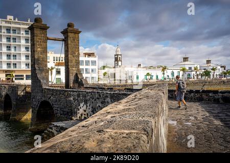 Ponte Puente de Las Bolas, in backgrount, campanile della chiesa di San Gines e municipio, Lanzarote, spagna Foto Stock