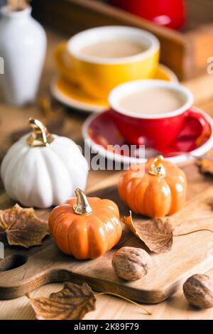 splendido sfondo autunnale con zucche e una tazza di caffè. decorazioni autunnali negli interni Foto Stock