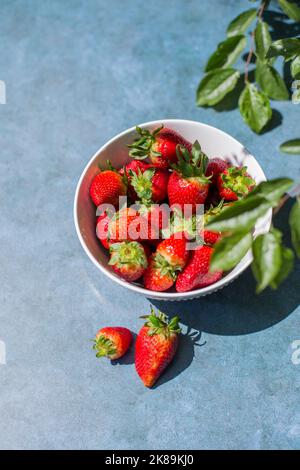 ciotola piena di fragole su sfondo astratto. Concetto di cibo sano, frutta. Foto Stock