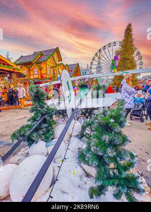 KIEV, UCRAINA - 2 GENNAIO 2022: Il vicolo del mercatino di Natale sulla piazza del contratto è decorato con un piccolo modello d'annata del velivolo con Natale Foto Stock