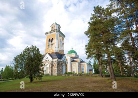 Vista dell'antico campanile e della chiesa in legno a Kerimyaki in una mattinata nuvolosa di giugno. Finlandia Foto Stock