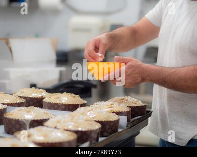 chef topping panettone torta italiana con mandorle Foto Stock